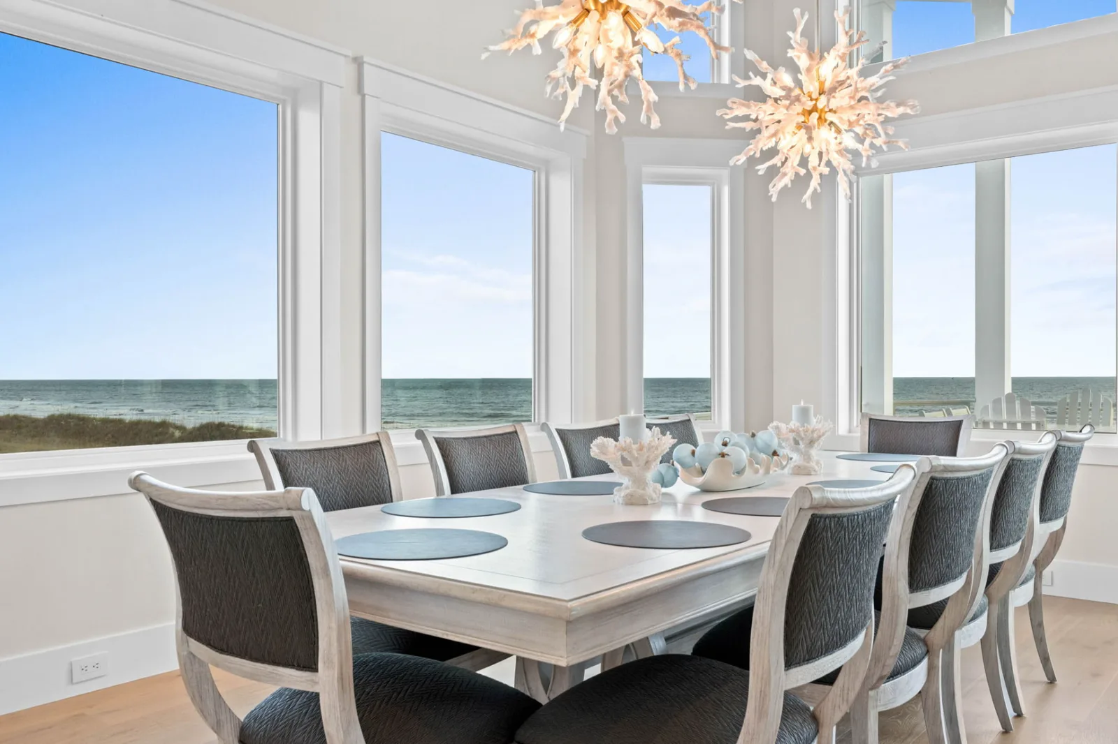 Oceanfront dining room with coral-inspired chandeliers and expansive ocean views
